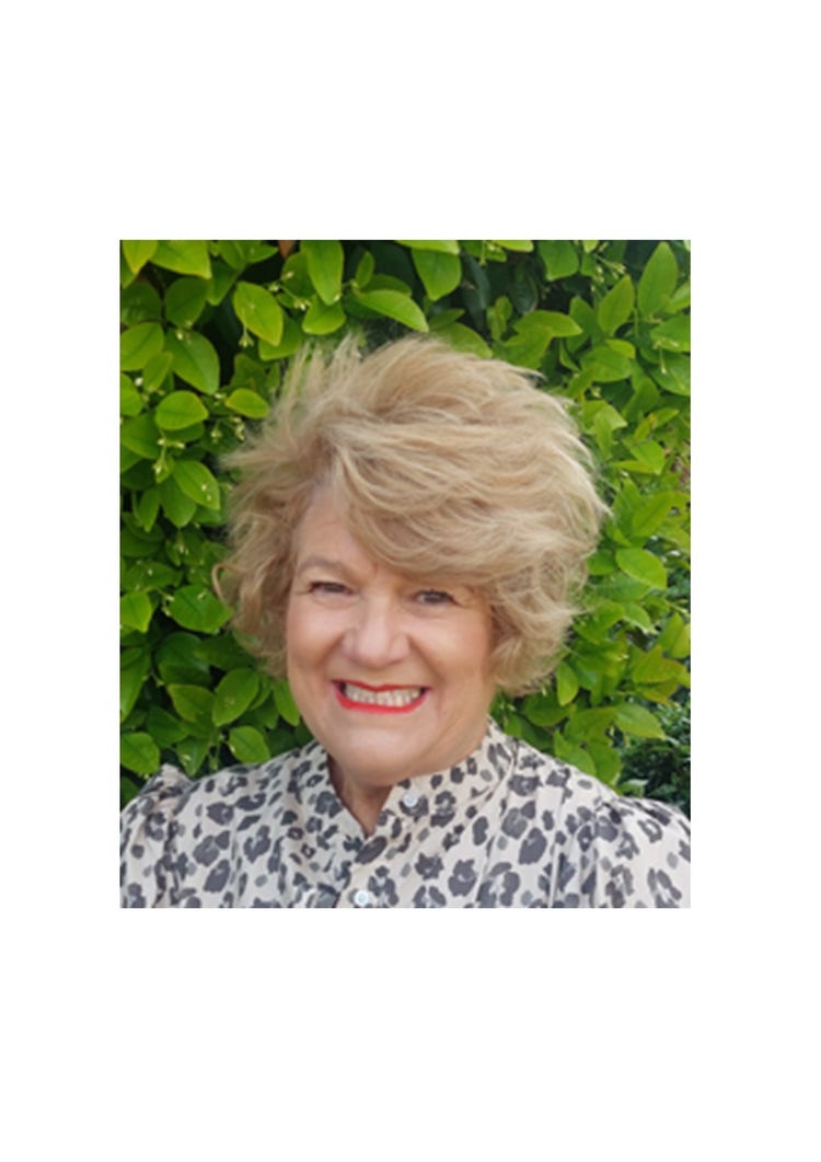 A photo of Spring Hill Public School Principal, Ann Marie McAnulty. Ann Marie is a middle aged lady with short blonde hair and is wearing a printed cream and grey printed shirt.